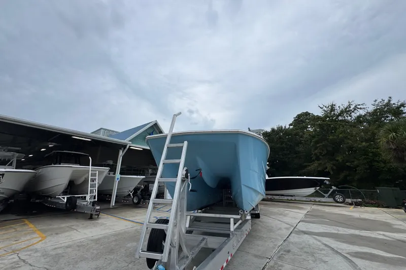 Slide: The Image of 2025 Invincible 40 Catamaran on trailer at marina, cloudy sky background. - 6