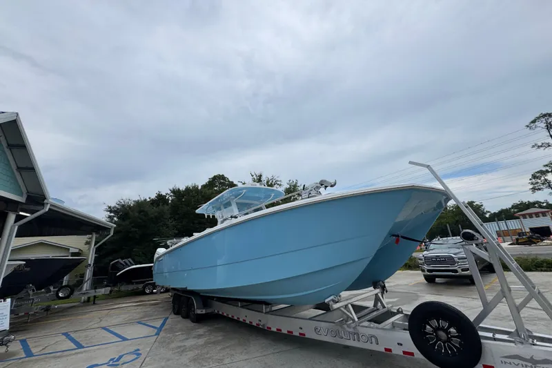 Slide: The Image of 2025 Invincible 40 Catamaran in light blue on a trailer, parked outdoors. - 9