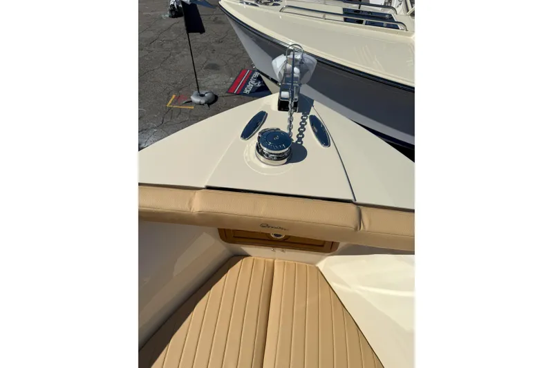 Slide: The Image of 2026 Rossiter 23 Open Bow boat with tan seating and anchor chain detail. - 11