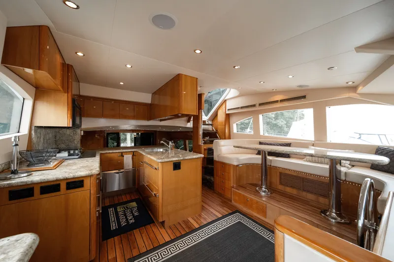 Slide: The Image of Interior of a 2008 Hatteras 64 Motor Yacht featuring elegant wood finishes and a modern kitchen. - 49