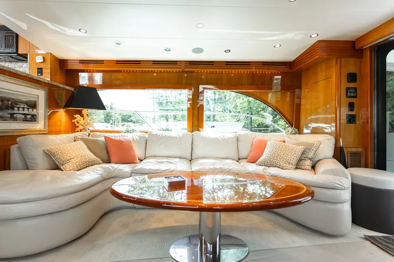 Slide: The Image of Luxurious salon of a 2008 Hatteras 64 Motor Yacht with elegant leather couch and wooden table. - 25