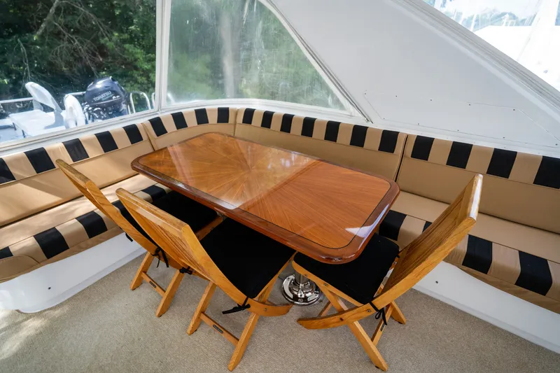 Slide: The Image of The interior of a 2008 Hatteras 64 Motor Yacht features an elegant wooden table with chairs. - 40