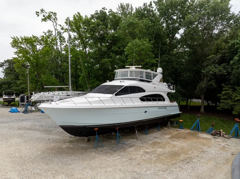 Slide: The Image of A 2008 Hatteras 64 Motor Yacht is on a dry dock, surrounded by trees. - 3
