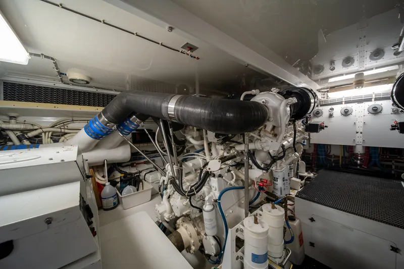 Slide: The Image of The engine room of a 2008 Hatteras 64 Motor Yacht features complex engines and piping. - 10