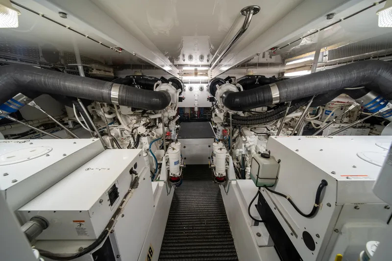Slide: The Image of The engine room of a 2008 Hatteras 64 Motor Yacht features two large engines and piping. - 8