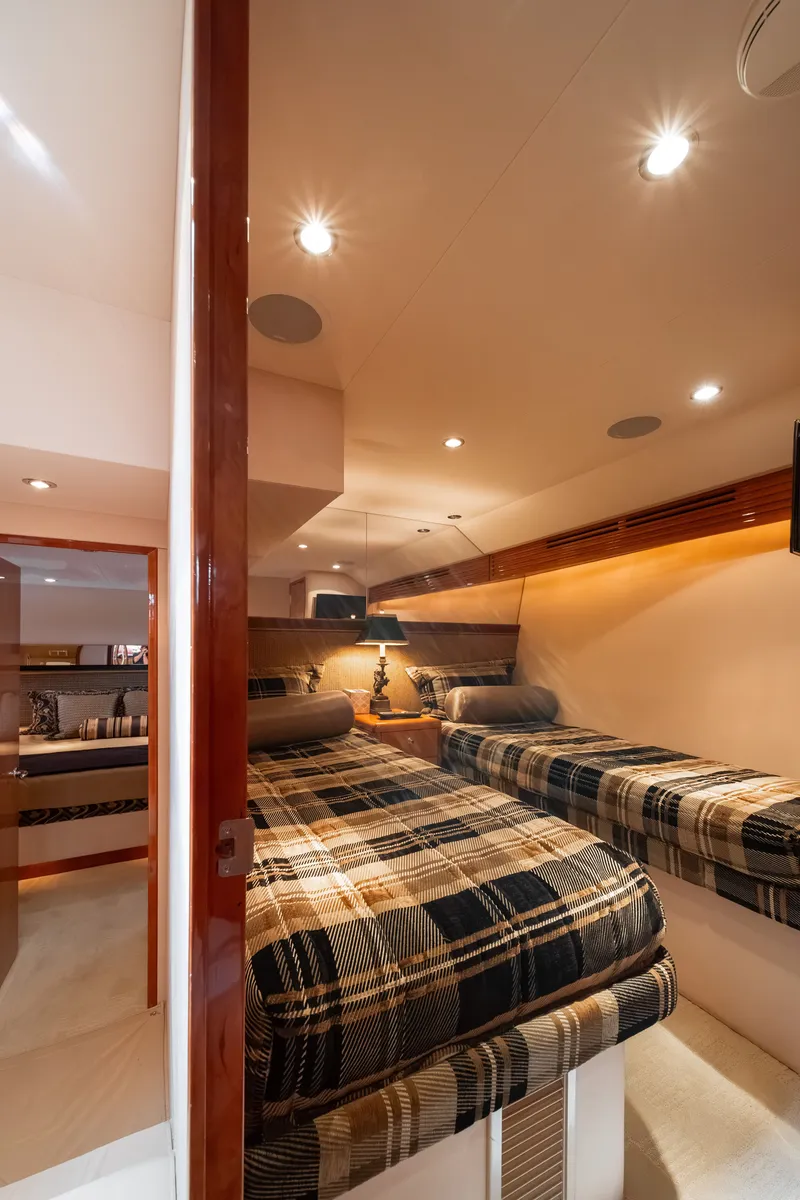 Slide: The Image of The 2008 Hatteras 64 Motor Yacht cabin features two single beds with plaid bedding. - 16