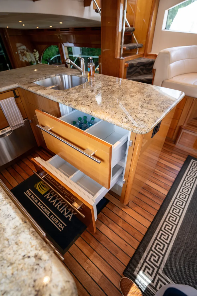 Slide: The Image of The 2008 Hatteras 64 Motor Yacht's kitchen features a granite countertop and open drawers. - 35