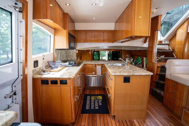 Slide: The Image of The 2008 Hatteras 64 Motor Yacht's kitchen features elegant wood cabinetry and granite countertops. - 34