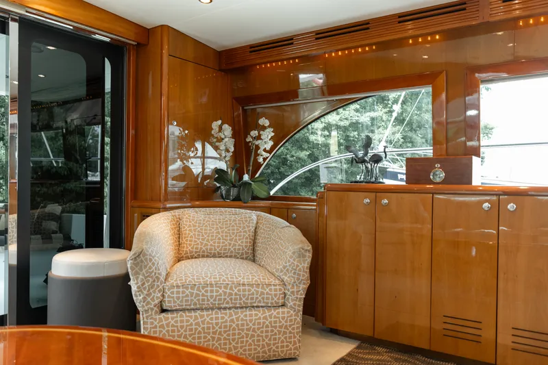 Slide: The Image of Luxurious salon with upholstered chair, wooden cabinetry, and large windows on a Hatteras 64 Motor Yacht. - 27