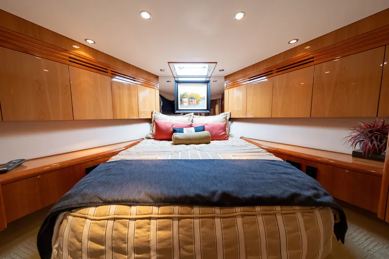 Slide: The Image of Luxurious bedroom with a large bed, wooden cabinetry, and a skylight on a Hatteras 64 Motor Yacht. - 13