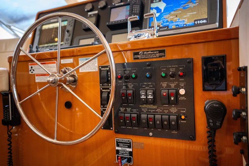 Slide: The Image of The image shows the helm of a 2008 Hatteras 64 Motor Yacht with navigation equipment and switches. - 32