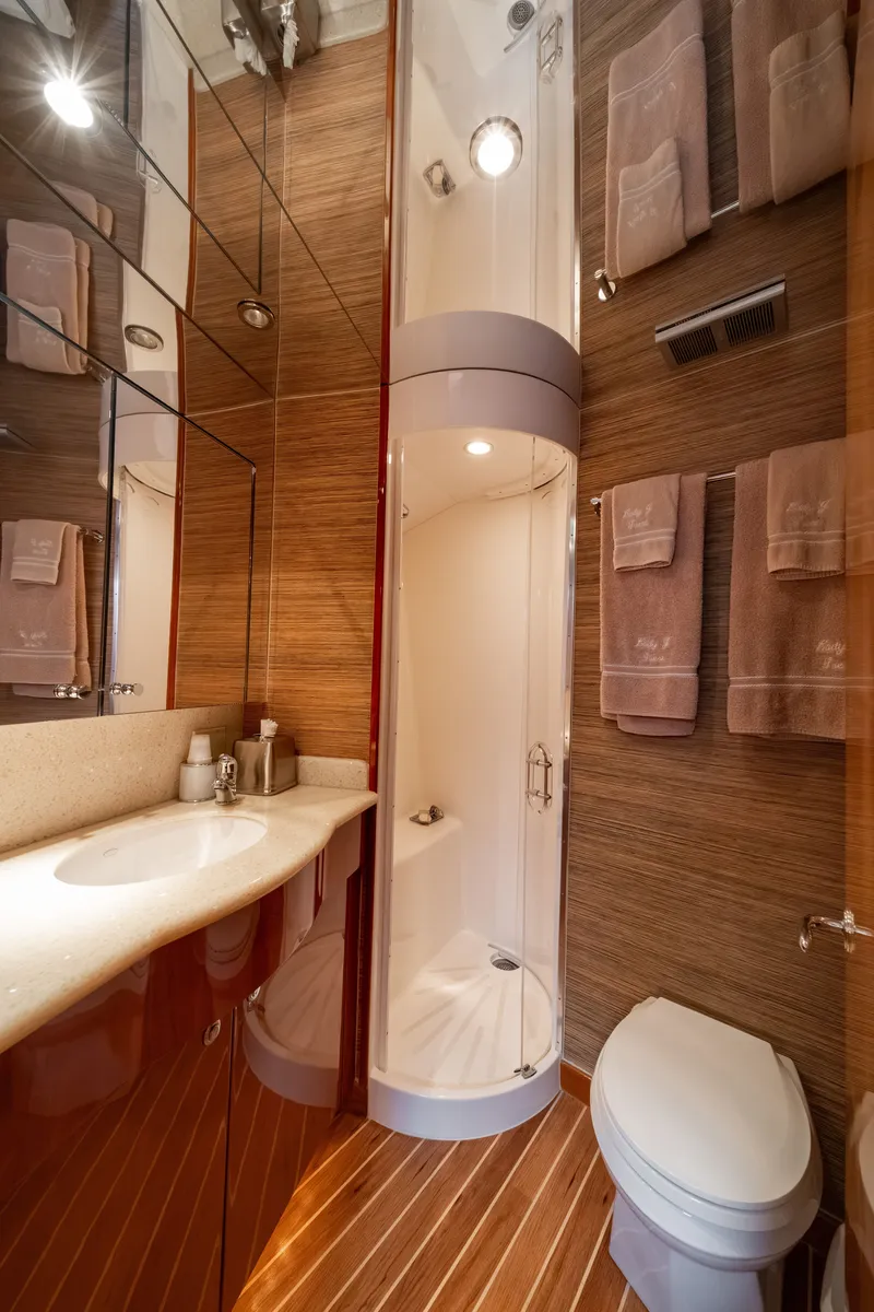Slide: The Image of Luxurious bathroom with wood paneling, shower, sink, and toilet on a Hatteras 64 Motor Yacht. - 14