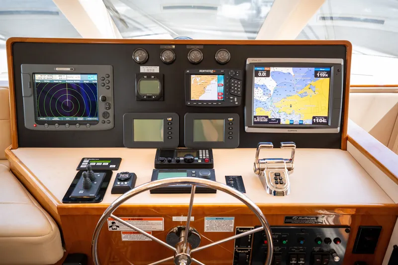 Slide: The Image of The image shows the helm of a 2008 Hatteras 64 Motor Yacht with modern navigation equipment. - 30