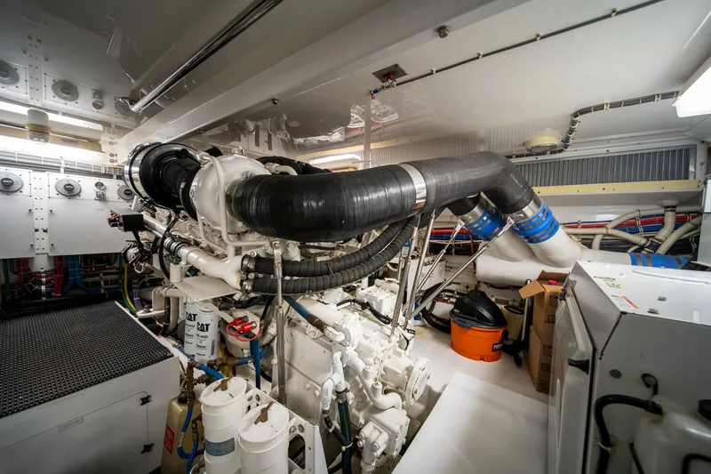 Slide: The Image of The engine room of a 2008 Hatteras 64 Motor Yacht features complex piping and machinery. - 9