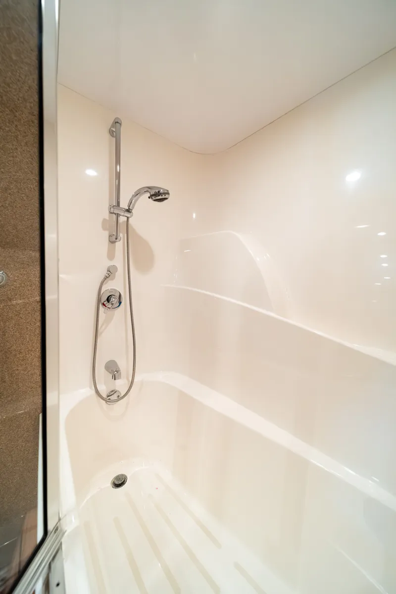 Slide: The Image of A modern shower stall with a handheld showerhead and glossy walls in a boat bathroom. - 20