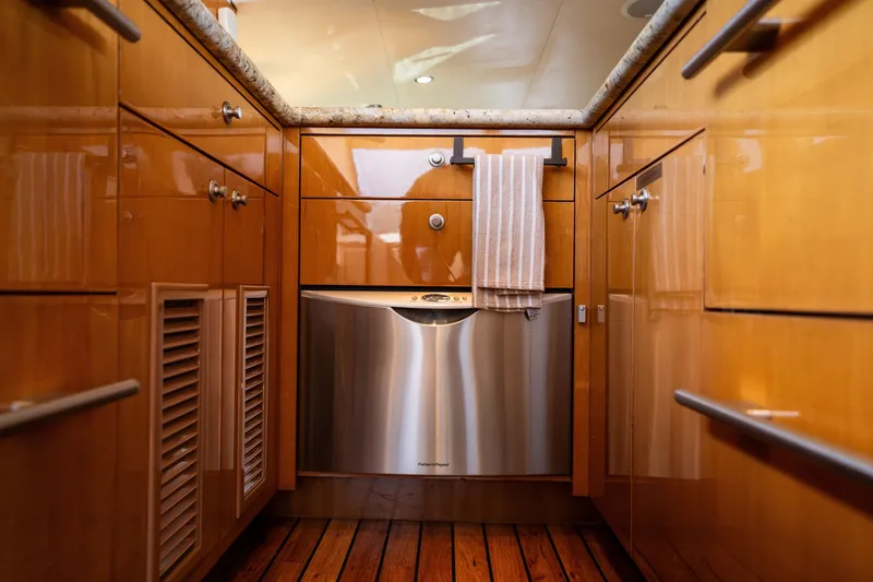 Slide: The Image of The galley of a 2008 Hatteras 64 Motor Yacht with wooden cabinets and stainless steel appliances. - 38