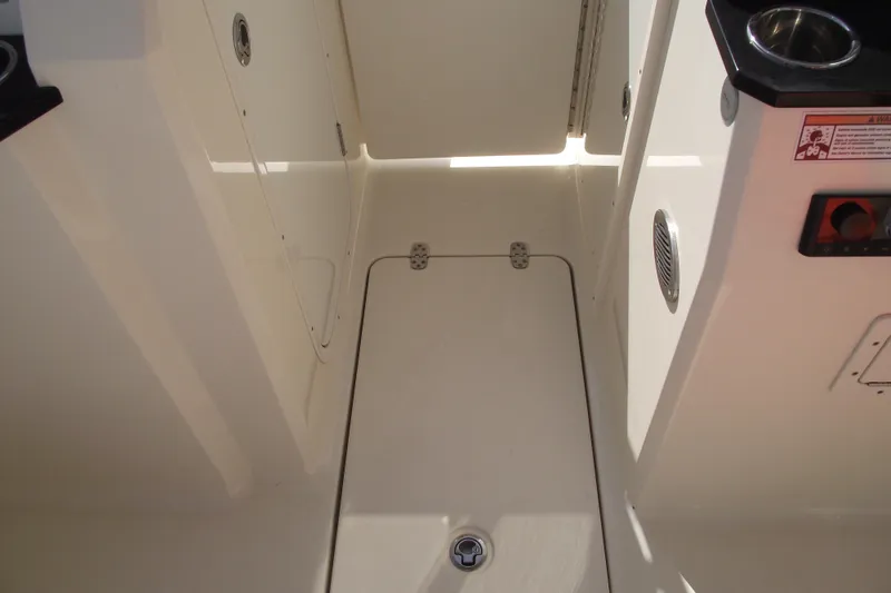 Slide: The Image of 2022 Scout 215 Dorado boat interior with storage compartment and cup holder. - 13