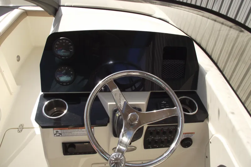 Slide: The Image of 2022 Scout 215 Dorado boat dashboard with steering wheel and gauges. - 15