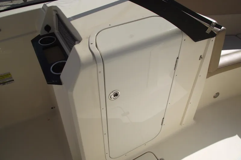 Slide: The Image of 2022 Scout 215 Dorado boat interior with storage compartment and cup holders. - 17