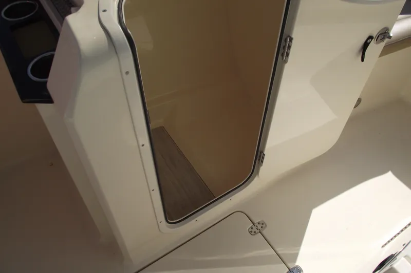 Slide: The Image of 2022 Scout 215 Dorado boat interior storage compartment with open door. - 18