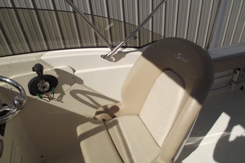 Slide: The Image of 2022 Scout 215 Dorado boat interior with steering wheel and beige seat. - 26