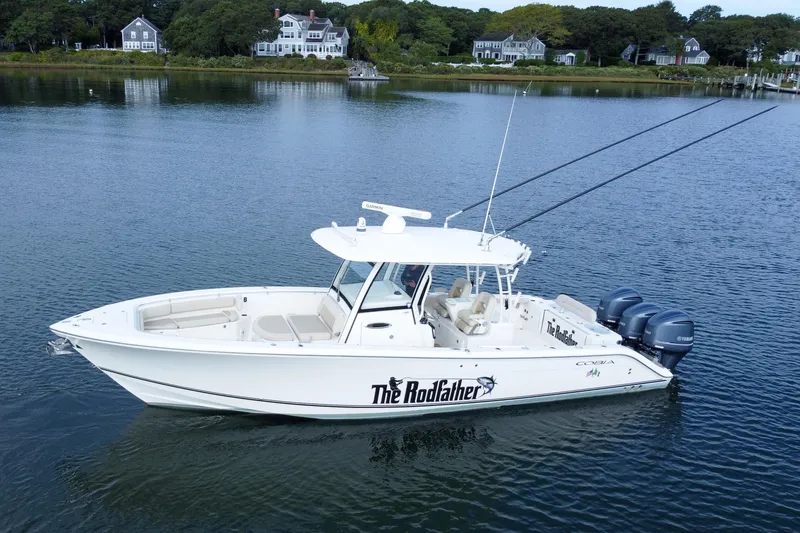 Slide: The Image of 2015 Cobia 344 Center Console boat on calm water, with scenic shoreline background. - 12