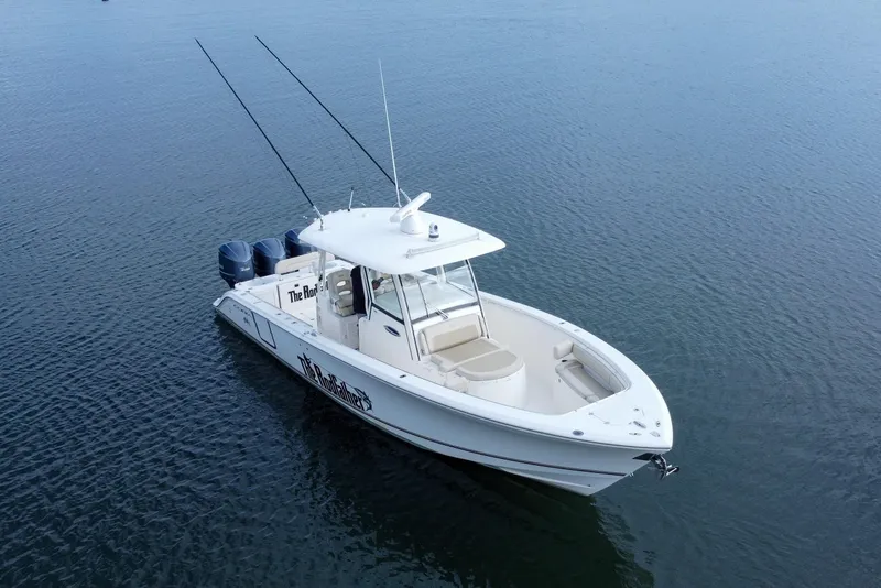 Slide: The Image of 2015 Cobia 344 Center Console boat on calm water, featuring dual outboard motors. - 16