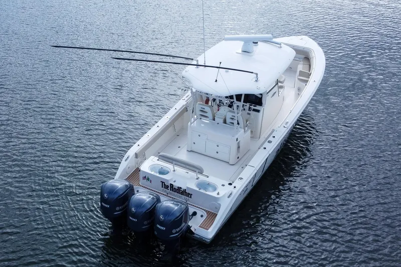 Slide: The Image of 2015 Cobia 344 Center Console boat with triple engines on calm water. - 18