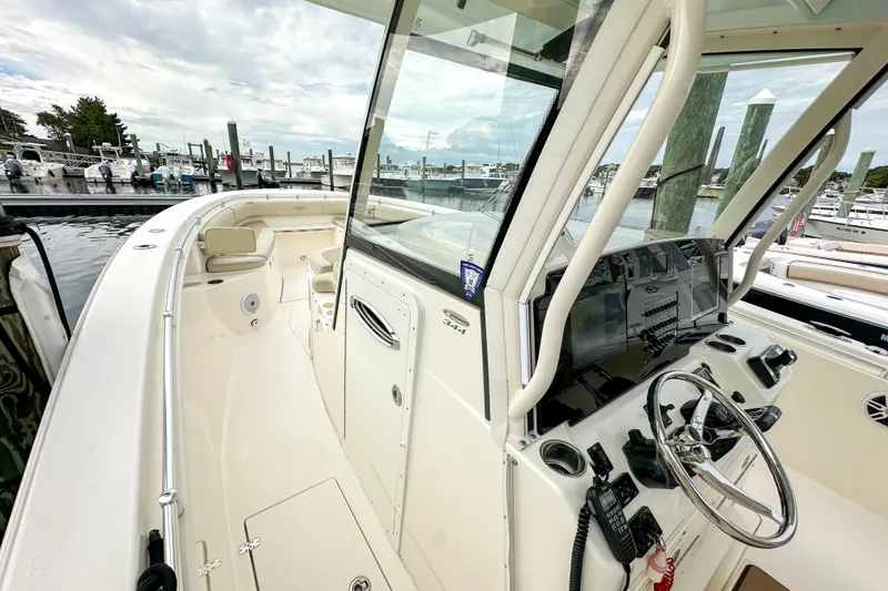 Slide: The Image of 2015 Cobia 344 Center Console boat docked, featuring spacious deck and modern controls. - 22