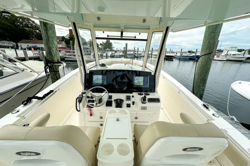 Slide: The Image of 2015 Cobia 344 Center Console boat interior with navigation system at marina. - 25