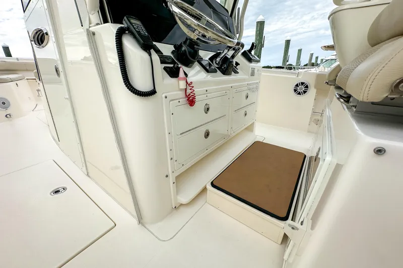 Slide: The Image of 2015 Cobia 344 Center Console boat interior with control panel and seating area. - 26