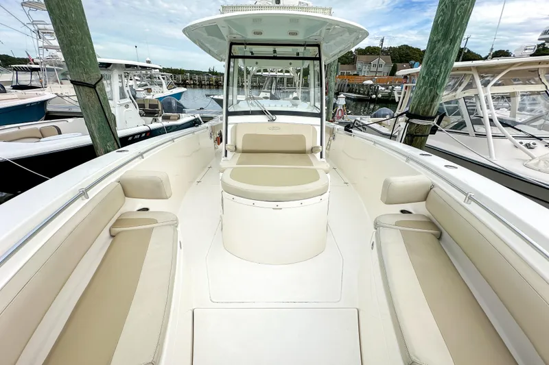 Slide: The Image of 2015 Cobia 344 Center Console boat with spacious seating at a marina. - 28