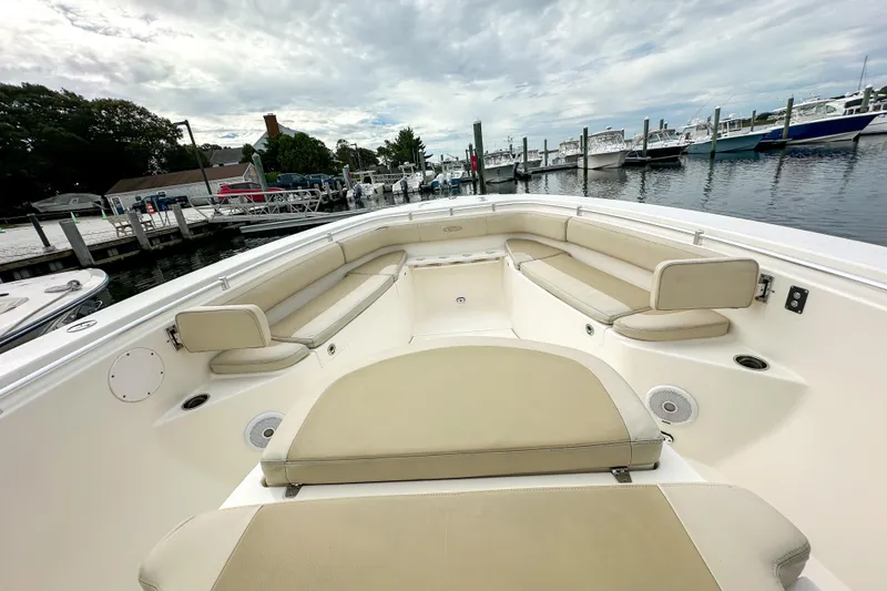 Slide: The Image of 2015 Cobia 344 Center Console boat with spacious seating at a marina. - 30