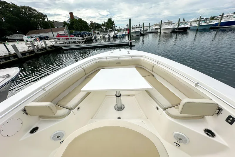 Slide: The Image of 2015 Cobia 344 Center Console boat with spacious seating and table at marina. - 31