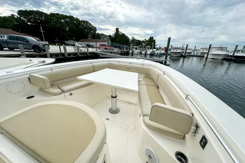 Slide: The Image of 2015 Cobia 344 Center Console boat with spacious seating and table at marina. - 32