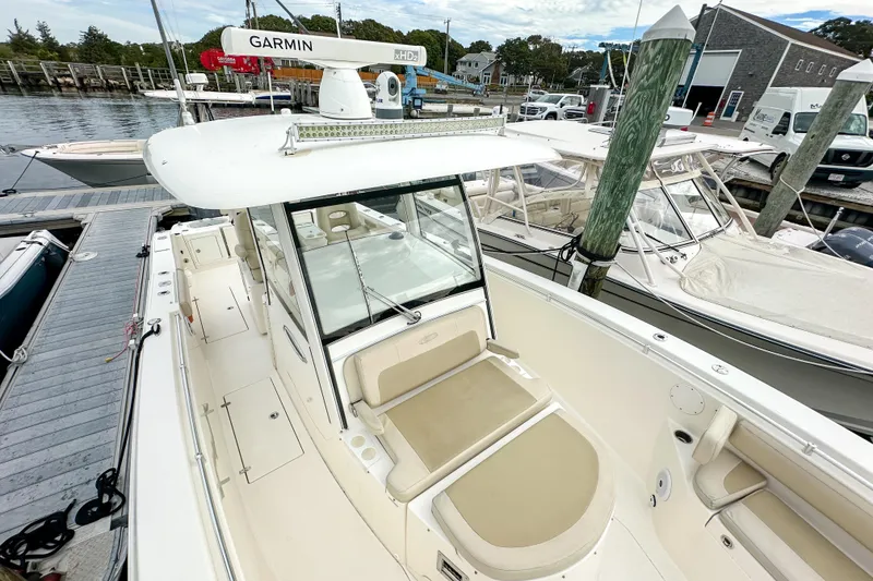 Slide: The Image of 2015 Cobia 344 Center Console boat docked, featuring Garmin radar and spacious seating. - 33