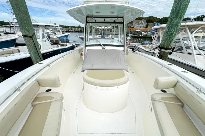 Slide: The Image of 2015 Cobia 344 Center Console boat docked at marina, featuring spacious seating. - 34