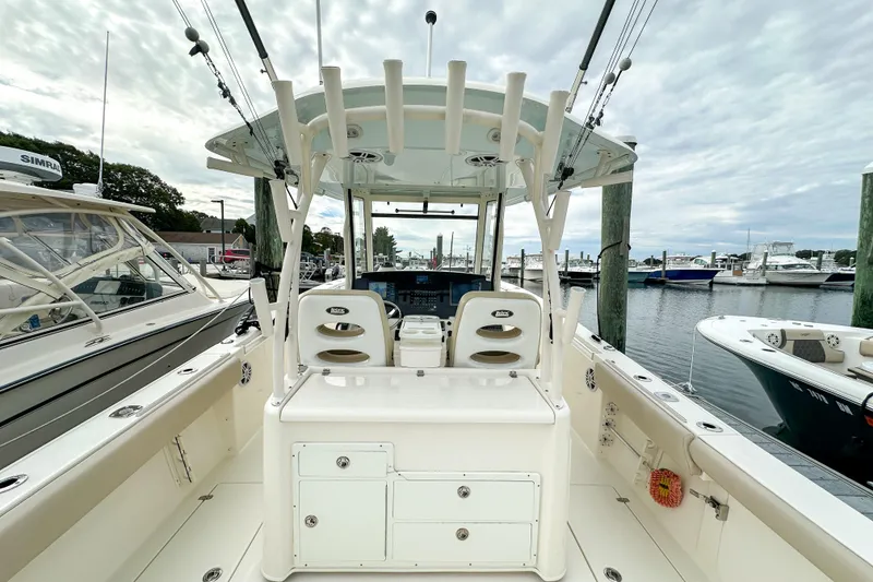 Slide: The Image of 2015 Cobia 344 Center Console boat docked at marina, featuring spacious seating and fishing equipment. - 36