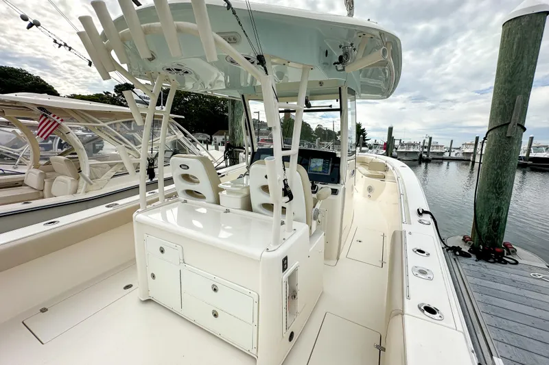 Slide: The Image of 2015 Cobia 344 Center Console boat docked at marina, featuring spacious deck and seating. - 37