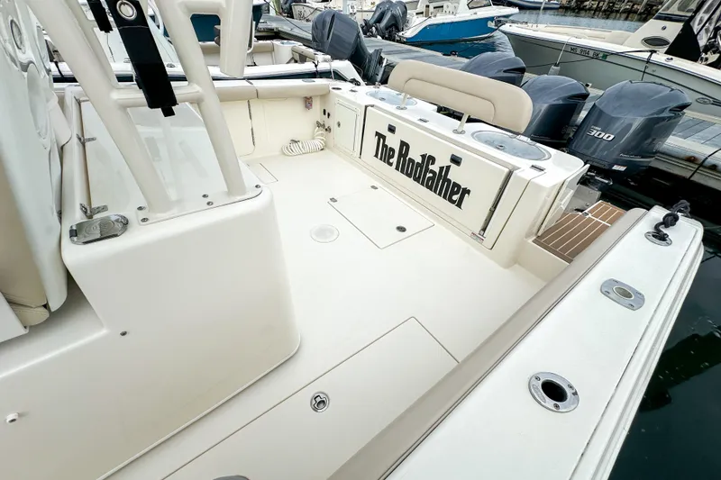 Slide: The Image of 2015 Cobia 344 Center Console boat with "The RodFather" text, docked with triple engines. - 41