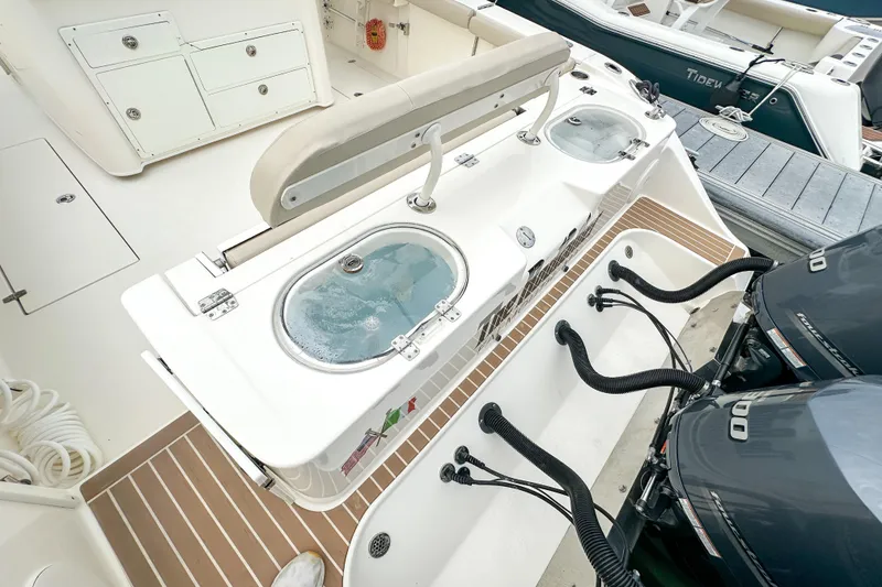 Slide: The Image of 2015 Cobia 344 Center Console boat with live wells and dual outboard engines. - 42