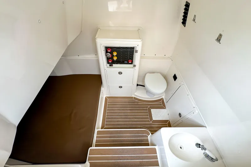 Slide: The Image of 2015 Cobia 344 Center Console interior with bed, toilet, and sink. - 44