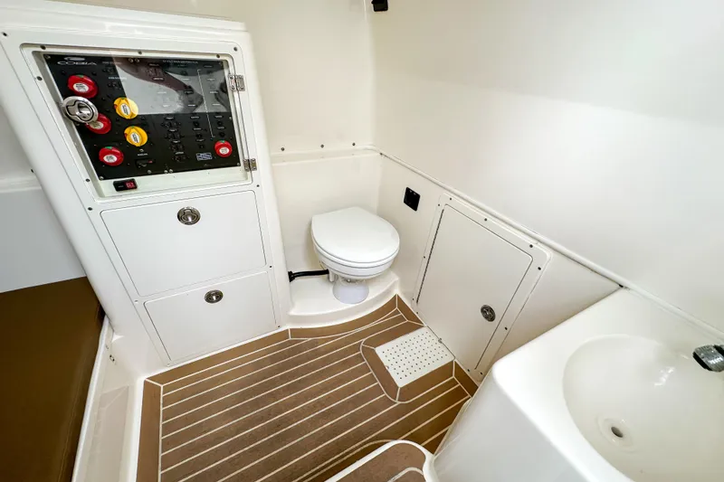 Slide: The Image of 2015 Cobia 344 Center Console boat interior with toilet and control panel. - 45