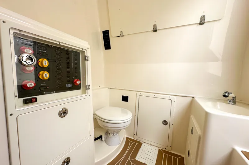 Slide: The Image of 2015 Cobia 344 Center Console boat interior with control panel and toilet. - 46