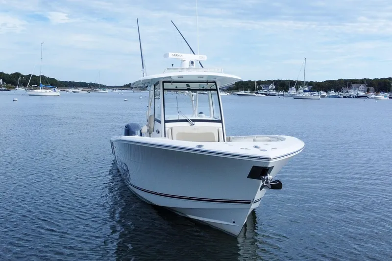 Slide: The Image of 2015 Cobia 344 Center Console boat on calm water, with marina in background. - 5