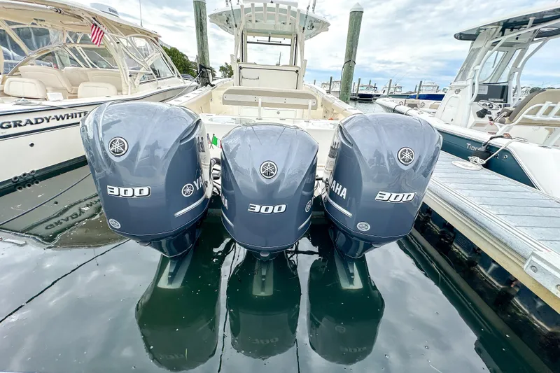 Slide: The Image of 2015 Cobia 344 Center Console with triple Yamaha 300 engines docked at marina. - 50