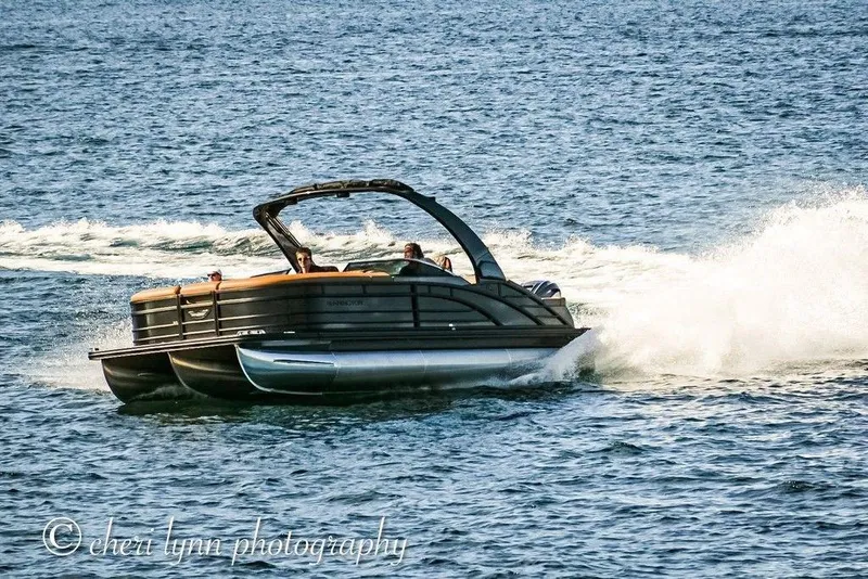 The Image of 2026 Bennington Swingback 25 pontoon boat cruising on open water. - 0