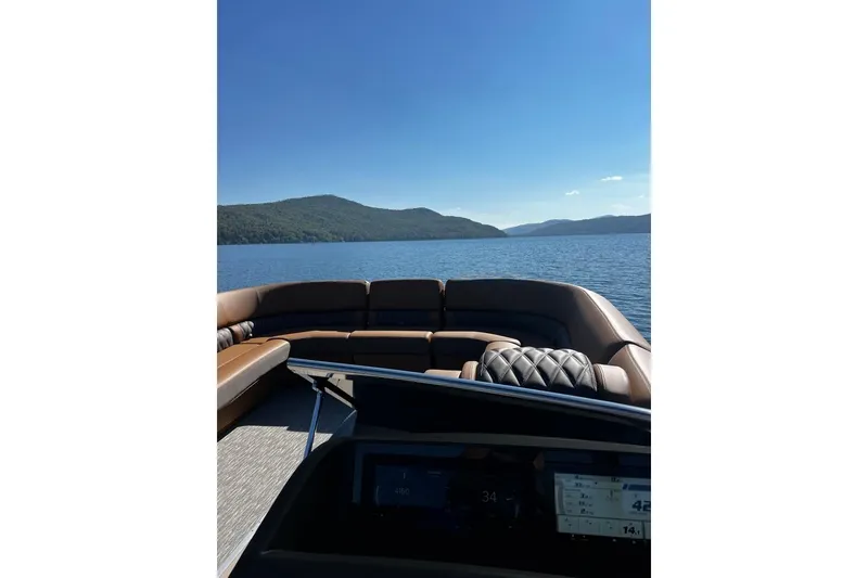 Slide: The Image of 2026 Bennington Swingback 25 on serene lake with scenic mountain backdrop. - 16