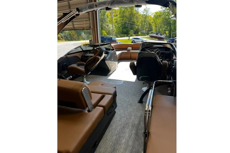 Slide: The Image of 2026 Bennington Swingback 25 boat interior with brown seating and modern dashboard. - 9