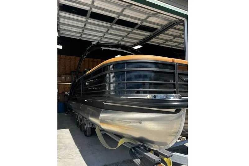 Slide: The Image of 2026 Bennington Swingback 25 pontoon boat in a garage setting. - 10